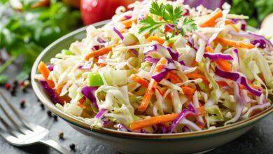 Cabbage carrot celery onion and apple coleslaw in a bowl