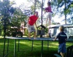 Dad and kids jumping on trampoline