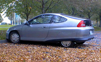 Electric car parked in log with leaves