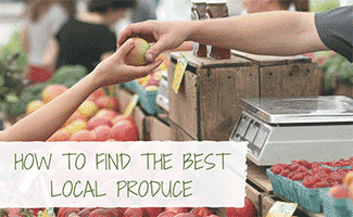 Woman being handed a ripe apple in market (Caption: How To Find The Best Local Produce)